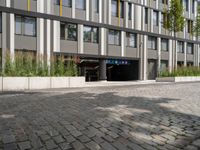 an open doorway and parking garage next to a building with a flag hanging from it's roof