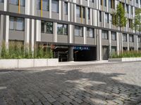 an open doorway and parking garage next to a building with a flag hanging from it's roof