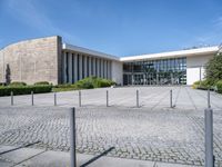 a white building with a large parking lot next to it and concrete floors, in front of a blue sky