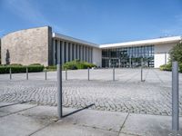 a white building with a large parking lot next to it and concrete floors, in front of a blue sky