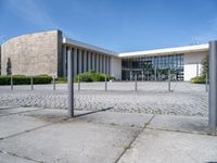 a white building with a large parking lot next to it and concrete floors, in front of a blue sky