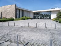 a white building with a large parking lot next to it and concrete floors, in front of a blue sky