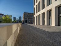 an empty sidewalk near buildings in a city area of europe, in front of blue sky