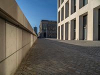 an empty sidewalk near buildings in a city area of europe, in front of blue sky