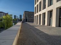 an empty sidewalk near buildings in a city area of europe, in front of blue sky