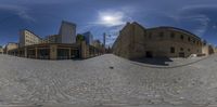 fisheye lens shot of old city street with buildings and trees in the foreground