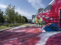 a building painted with colorful street art in red, blue, and green colors is shown