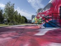 a building painted with colorful street art in red, blue, and green colors is shown