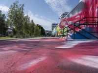 a building painted with colorful street art in red, blue, and green colors is shown