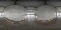 a view from under the inside of an open area in concrete domes, with the ceiling and columns showing