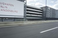 an industrial building with large outdoor advertising on the side of it, along with a bicycle next to it