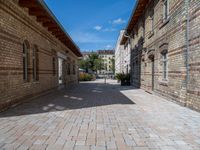 a street in an old, deserted european city has bricks and concrete flooring on each side