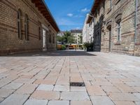 a street in an old, deserted european city has bricks and concrete flooring on each side