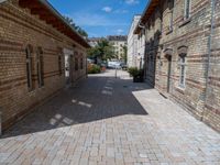 a street in an old, deserted european city has bricks and concrete flooring on each side