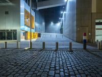 a courtyard with the door open at night in the middle of a building with several lamps