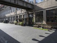 a very pretty courtyard with lots of wooden benches in it and large windows and large windows