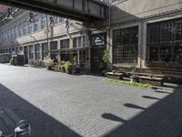 a very pretty courtyard with lots of wooden benches in it and large windows and large windows