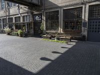 a very pretty courtyard with lots of wooden benches in it and large windows and large windows