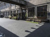 a very pretty courtyard with lots of wooden benches in it and large windows and large windows