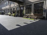 a very pretty courtyard with lots of wooden benches in it and large windows and large windows