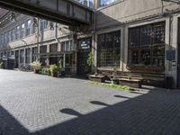 a very pretty courtyard with lots of wooden benches in it and large windows and large windows