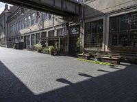 a very pretty courtyard with lots of wooden benches in it and large windows and large windows