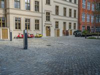 an empty parking lot with plants in the ground and on the side of the building, there is an enclosed area and windows