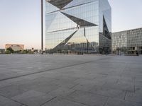 an outdoor area is seen in the background and a large glass building stands with a metal structure near it