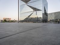 an outdoor area is seen in the background and a large glass building stands with a metal structure near it