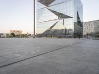 an outdoor area is seen in the background and a large glass building stands with a metal structure near it