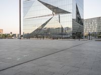 an outdoor area is seen in the background and a large glass building stands with a metal structure near it