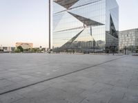 an outdoor area is seen in the background and a large glass building stands with a metal structure near it