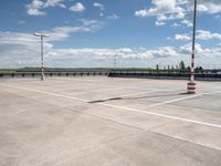 a empty parking lot with an orange traffic cone and red cones on top of it