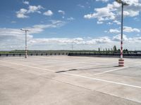 a empty parking lot with an orange traffic cone and red cones on top of it