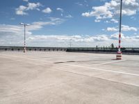 a empty parking lot with an orange traffic cone and red cones on top of it