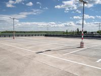 a empty parking lot with an orange traffic cone and red cones on top of it