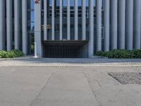 the side of a building with trees on either side and other bushes on the other side