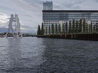 large body of water next to a building near the river with people on it and boats in the water