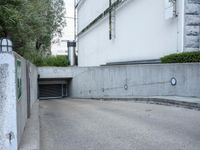 a parking garage with an opened door and a sidewalk in the background in an urban setting