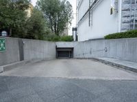 a parking garage with an opened door and a sidewalk in the background in an urban setting