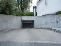a parking garage with an opened door and a sidewalk in the background in an urban setting
