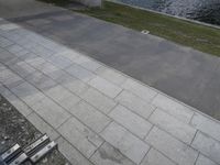 there is a person riding their bicycle on the sidewalk next to the water near a bench