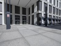 a very tall building with black shutters and glass windows on the front of it