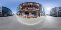 a fish - eye lens image of an outside building and some benches and other parked cars