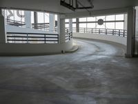 a big empty parking garage with concrete floors and walls on either side of the building