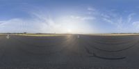 an empty runway with some clouds and sun setting behind it is an image of a beautiful sky