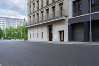 a man is riding his skateboard on the empty street and building in the background