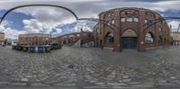 a fish eye view of an entrance to some old buildings in the background, in a city