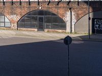 an empty parking lot next to the side of an old brick building in a town