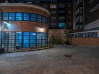 some dark blue windows in an industrial building with no one on the street to the right